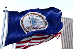 Virginia state flag waving in front of the U.S. flag.