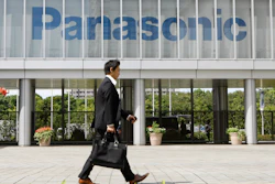 A businessman walks past a corporate logo of Japanese electronics maker Panasonic Corp. at Panasonic Center in Tokyo, Japan, Sept. 10, 2009.