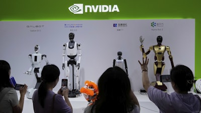 Visitors give commands to a robot at Nvidia's booth during the 3rd China International Supply Chain Expo at the China International Exhibition Center, in Beijing, China, Friday, July 18, 2025.