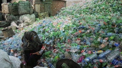 A female worker sorts through empty bottles at a plastic recycling factory in Lahore, Pakistan, Thursday, Aug. 7, 2025.