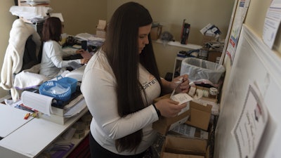 Amanda Follett works on packages at A Sight For Sport Eyes, a brick-and-mortar and e-commerce store for sport goggles, Aug. 20, 2025, in West Linn, Ore.