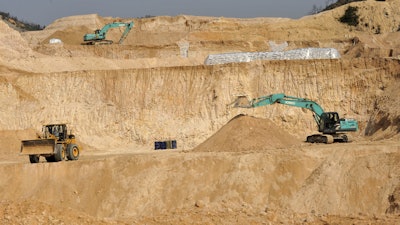 Workers use machinery to dig at a rare earth mine in Ganxian county in central China's Jiangxi province on Dec. 30, 2010.