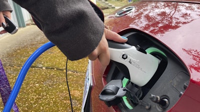 Rebecca DeWhitt charges her electric vehicle on Sept. 30, 2022, in the driveway of the Portland, Ore., home she rents.