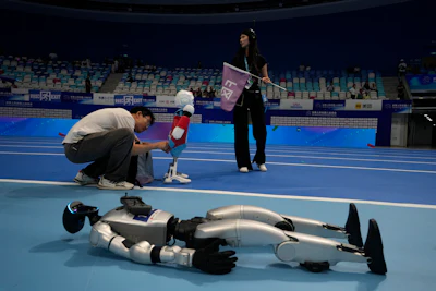 A worker prepares a robot before the opening ceremony of The World Humanoid Robot Games held in Beijing, China, Thursday, Aug. 14, 2025.