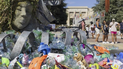 Plastic items are seen next to an artwork by Canadian artist and activist Benjamin Von Wong, titled 'The Thinker's Burden', a 6-meter-tall sculptural remix of Rodin's iconic Thinker, created especially for the Plastics Treaty negotiations, on Place des Nations in front of the European headquarters of the United Nations in Geneva, Switzerland, Monday, Aug. 4, 2025 before the second segment of the fifth session of the Intergovernmental Negotiating Committee on Plastic Pollution (INC-5.2).