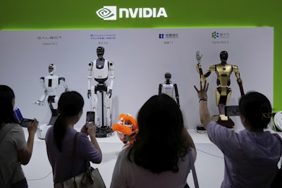 Visitors give commands to a robot at Nvidia's booth during the 3rd China International Supply Chain Expo at the China International Exhibition Center, in Beijing, July 18, 2025.