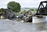 Train cars are immersed in the Yellowstone River after a bridge collapse near Columbus, Mont., June 24, 2023.