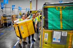 Amazon employees load packages on carts at Amazon's DAX7 delivery station, July 16, 2024, South Gate, Calif.