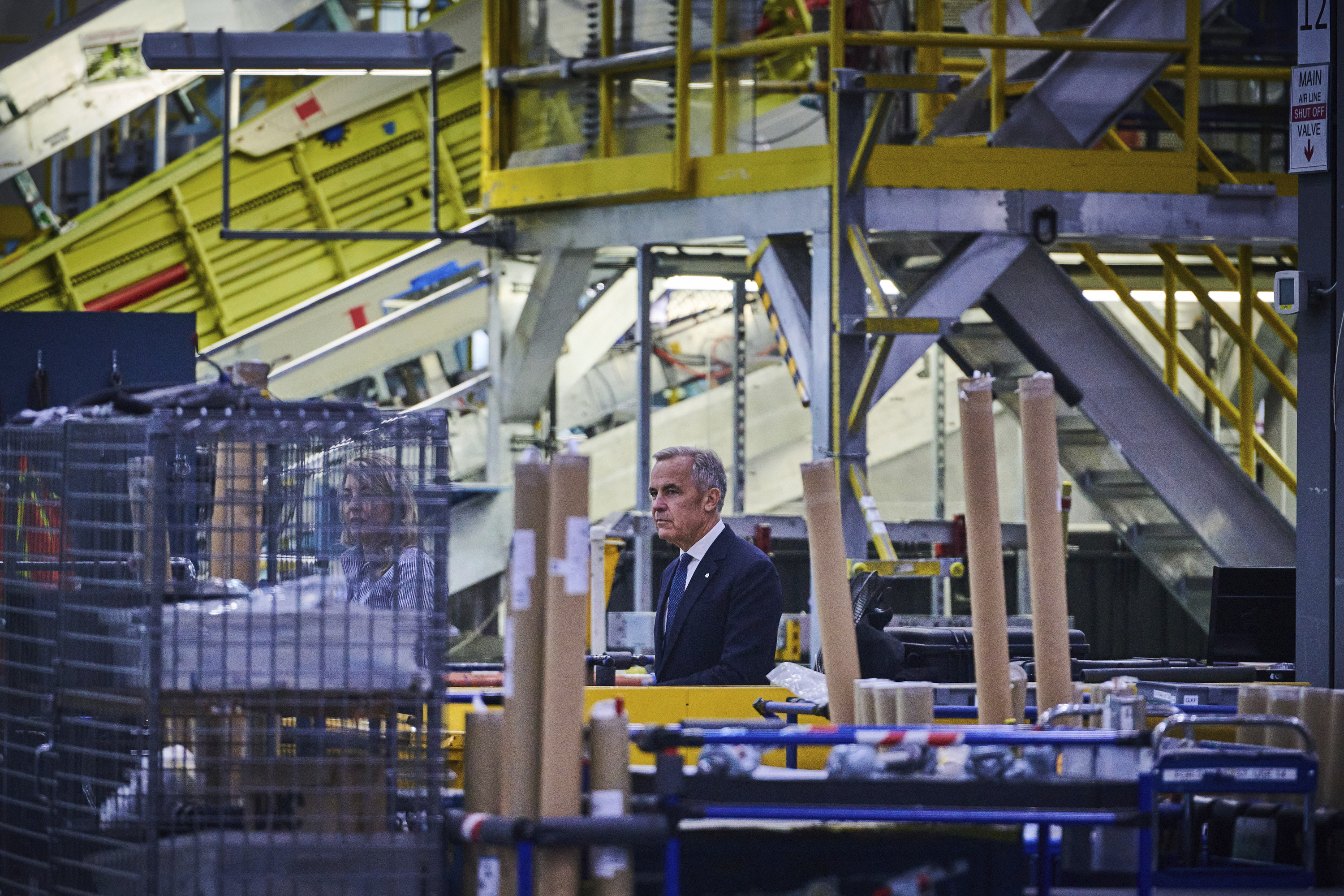 Prime Minister Mark Carney walks through a manufacturing facility ahead of a press conference in Mississauga, Ont., on Friday, Sept. 5, 2025.