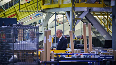 Prime Minister Mark Carney walks through a manufacturing facility ahead of a press conference in Mississauga, Ont., on Friday, Sept. 5, 2025.