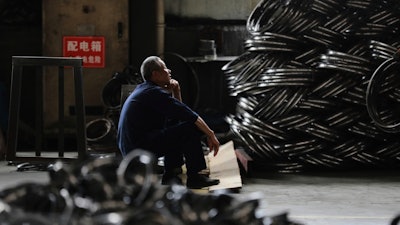 A worker takes a rest at a factory making steel bike rims for export to U.S., in Hangzhou in east China's Zhejiang province, on Friday, April 11, 2025.