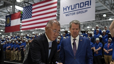 Euisun Chung, Executive Chair, Hyundai Motor Company, left, stands with Georgia Gov. Brian Kemp as Chung signs an IONIQ 9 EV vehicle during a media tour and grand opening at the Hyundai Motor Group Metaplant America, March 26, 2025, in Ellabell, Ga.