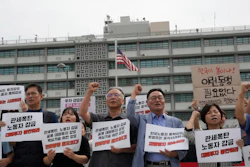 Protesters stage a rally against the detention of South Korean workers during an immigration raid in Georgia, near the U.S. Embassy in Seoul, South Korea, Tuesday, Sept. 9, 2025. The signs read 'A tariff bomb and workers confinement.'
