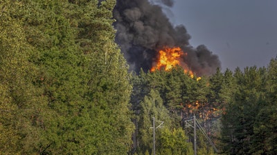 Smoke and flames rise following powerful explosions after several rail cars loaded with liquefied gas caught fire in the suburbs of Vilnius, Lithuania, Wednesday, Sept. 10, 2025.