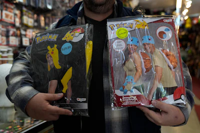 Owner Courtland Hickey holds a Pokémon costume from 2024, left, and one from this year, right, at Chicago Costume, Wednesday, Sept. 17, 2025, in Chicago.