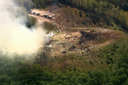 Smoke fills the air as debris covers the ground and vehicles after a powerful blast ripped through a military explosives manufacturing plant in Hickman County, Tenn., on Friday, Oct. 10, 2025.
