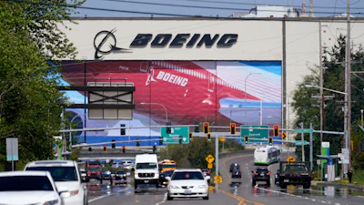 Traffic drives in view of a Boeing Co. production plant, where images of jets decorate the hangar doors on April 23, 2021, in Everett, Wash.