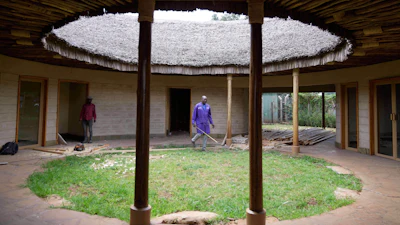 A contractor takes measurements inside a house under construction, inspecting wall and roof insulation made from agricultural waste and mushroom mycelium in Nairobi, Kenya, Friday, Sept. 12, 2025.