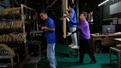 Workers check aluminum panels produced at a factory of Kam Pin Industrial (HK) Ltd, in Dongguan city in southern China's Guangdong province April 17, 2025.