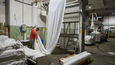 German Flores measures fabric at the Galfione Group textile factory in Buenos Aires, Argentina, Monday, Oct. 13, 2025.