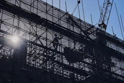 A worker installs scaffolding at a building under construction at the capital popular shopping district, in Beijing, Tuesday, Oct. 21, 2025.