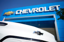 The company logo shines off the nose of an unsold 2022 Bolt electric vehicle on display in front of a Chevrolet dealership Sunday, Sept. 12, 2021, in Englewood, Colo.