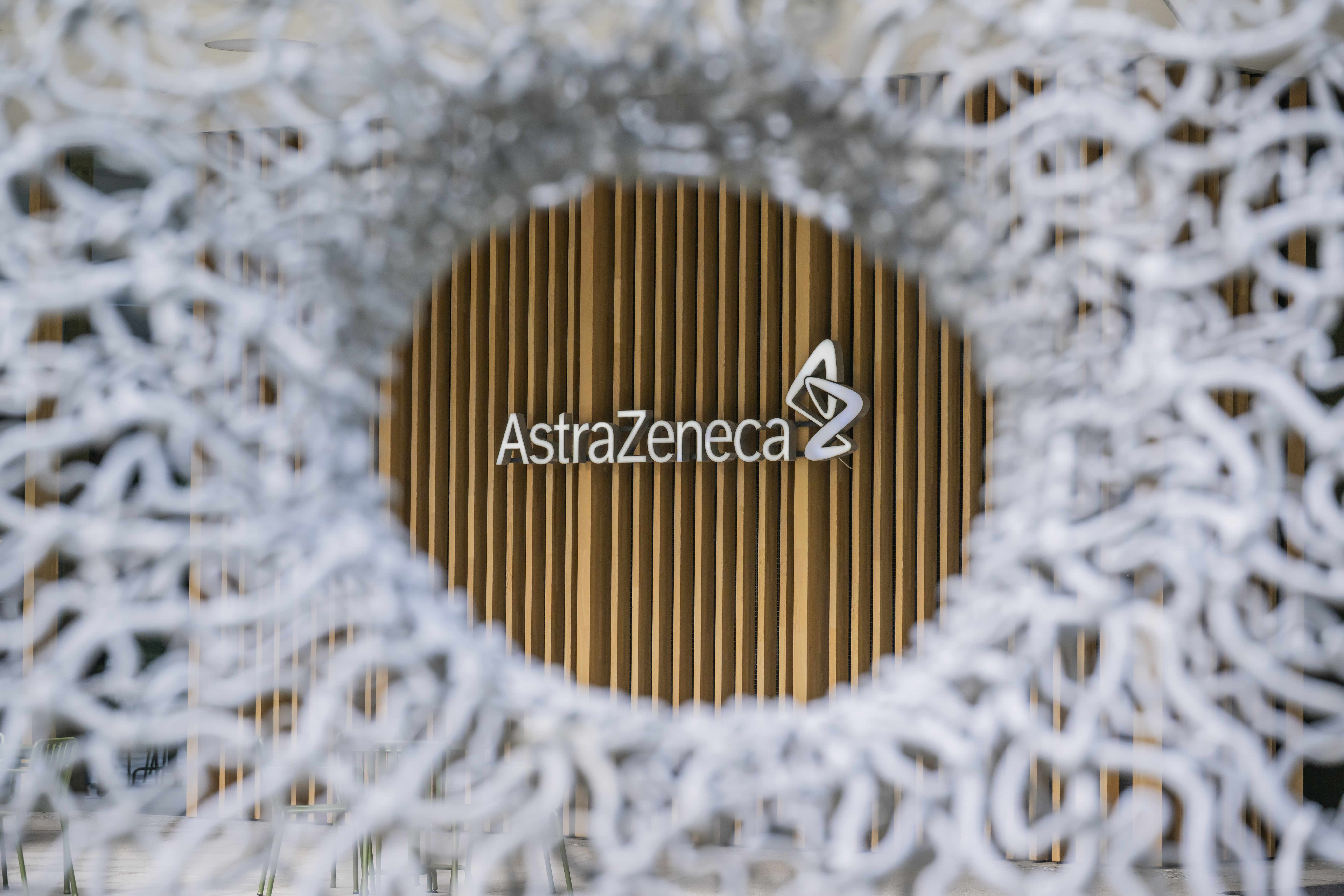 AstraZeneca corporate logo on golden circular background with textured white border