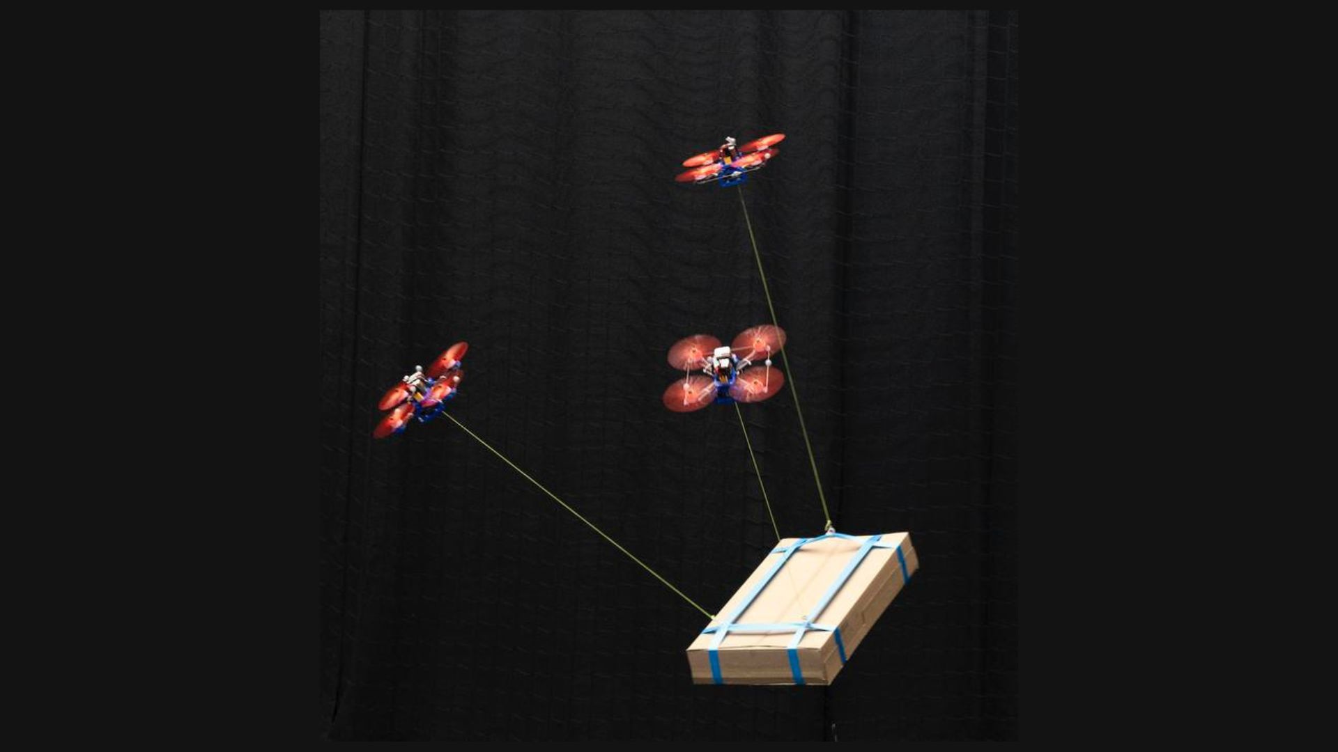 Three drones carry a load together, using the new algorithm developed at TU Delft, The Netherlands.