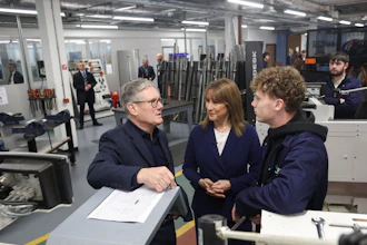 Business professionals discussing project in industrial workshop with machinery