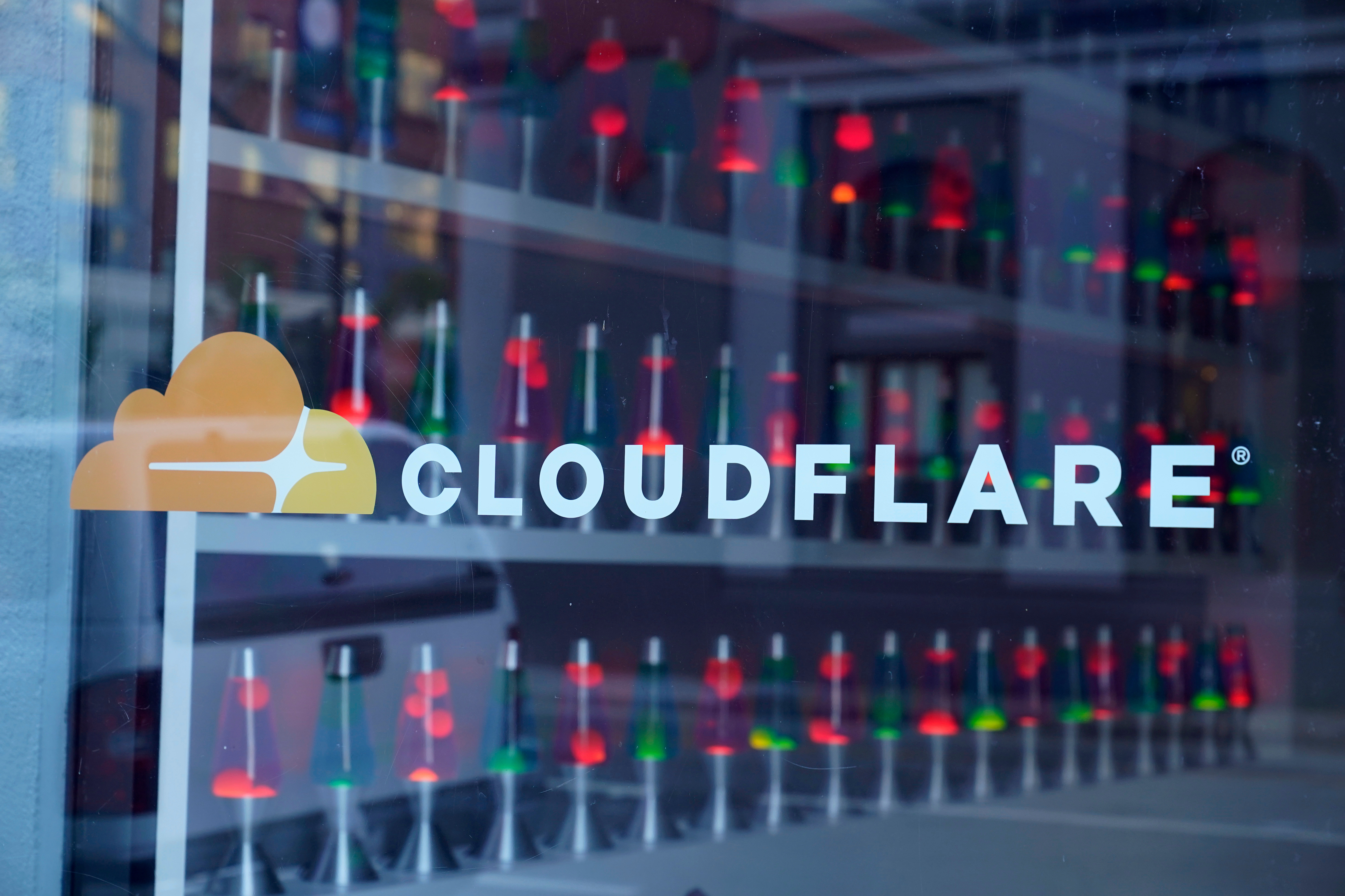 Lava lamps are seen through a lobby window at the headquarters of Cloudflare in San Francisco, Wednesday, Aug. 31, 2022.