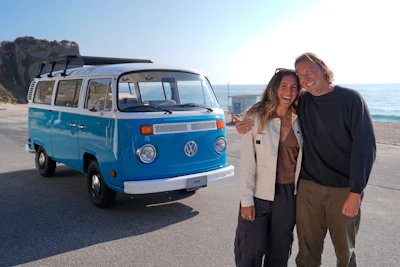 Megan Krystle Weinraub, left, and Preston Martin, who is the former owner, pose in front of her Volkswagen bus after seeing it for the first time Monday, Oct. 27, 2025, in Malibu, Calif., after it was restored by VW.