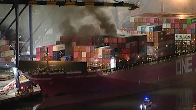 This image taken from video provided by ABC7 shows smoke rising from a blaze on a container ship docked at the Port of Los Angeles, Friday, Nov. 21, 2025, in Los Angeles.