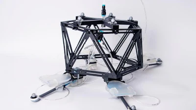 A photo of the unidirectional hopping robot which is composed of a black skeleton as the robot body, and four self-sensing oscillating actuators.