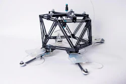 A photo of the unidirectional hopping robot which is composed of a black skeleton as the robot body, and four self-sensing oscillating actuators.