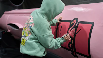 A painter writes 'Dana 1' referring to Czech nuclear physicist Dana Drabova on the side of a Flamingo cruise missile, which was paid by a crowdfunding campaign of a Czech organization, Weapons to Ukraine, at the Fire Point factory at an undisclosed location in Ukraine, Sunday, Nov. 16, 2025.
