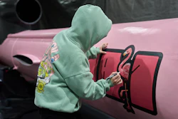 A painter writes 'Dana 1' referring to Czech nuclear physicist Dana Drabova on the side of a Flamingo cruise missile, which was paid by a crowdfunding campaign of a Czech organization, Weapons to Ukraine, at the Fire Point factory at an undisclosed location in Ukraine, Sunday, Nov. 16, 2025.