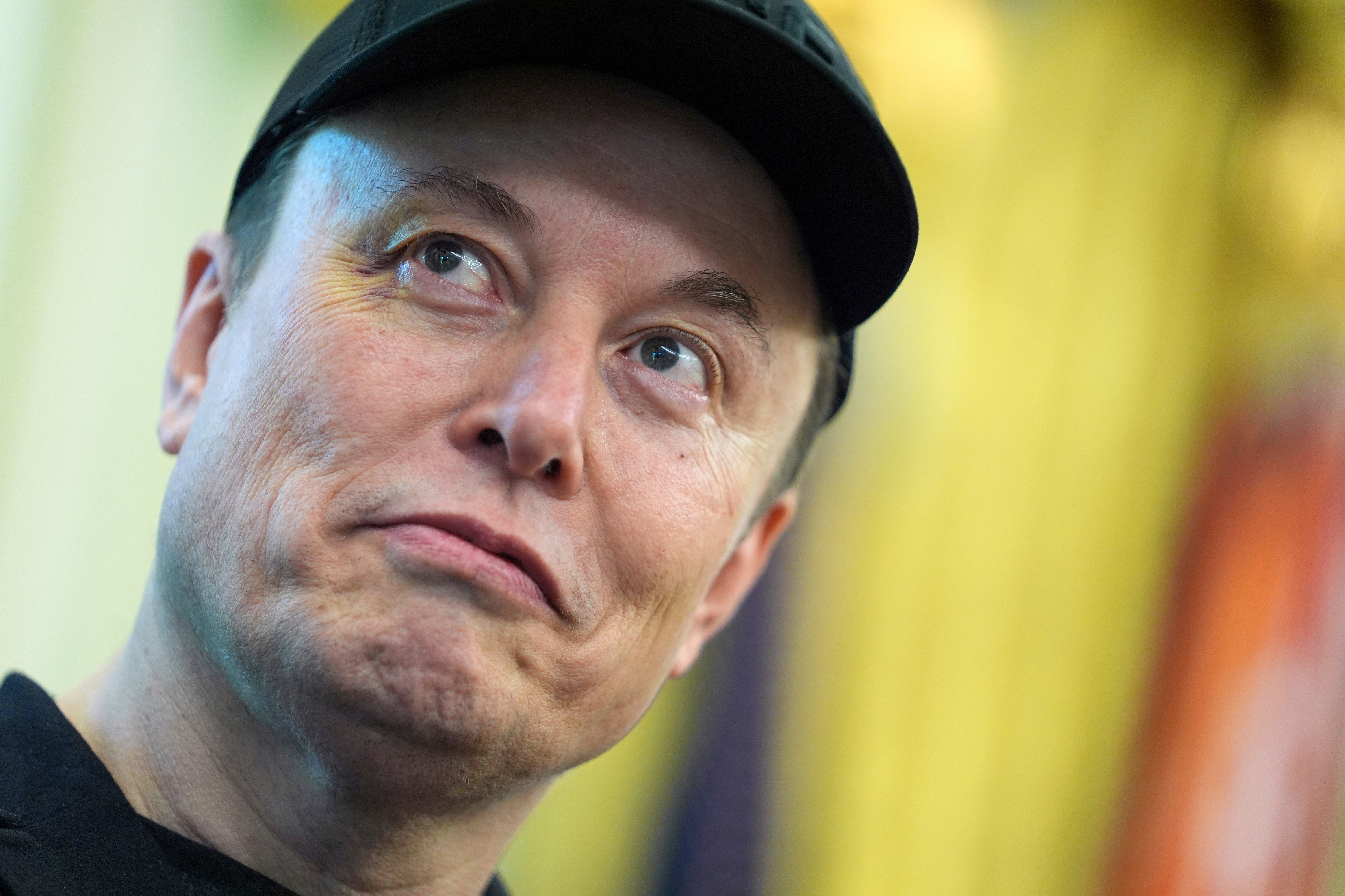 Elon Musk listens as President Donald Trump speaks during a news conference in the Oval Office of the White House, May 30, 2025, in Washington.