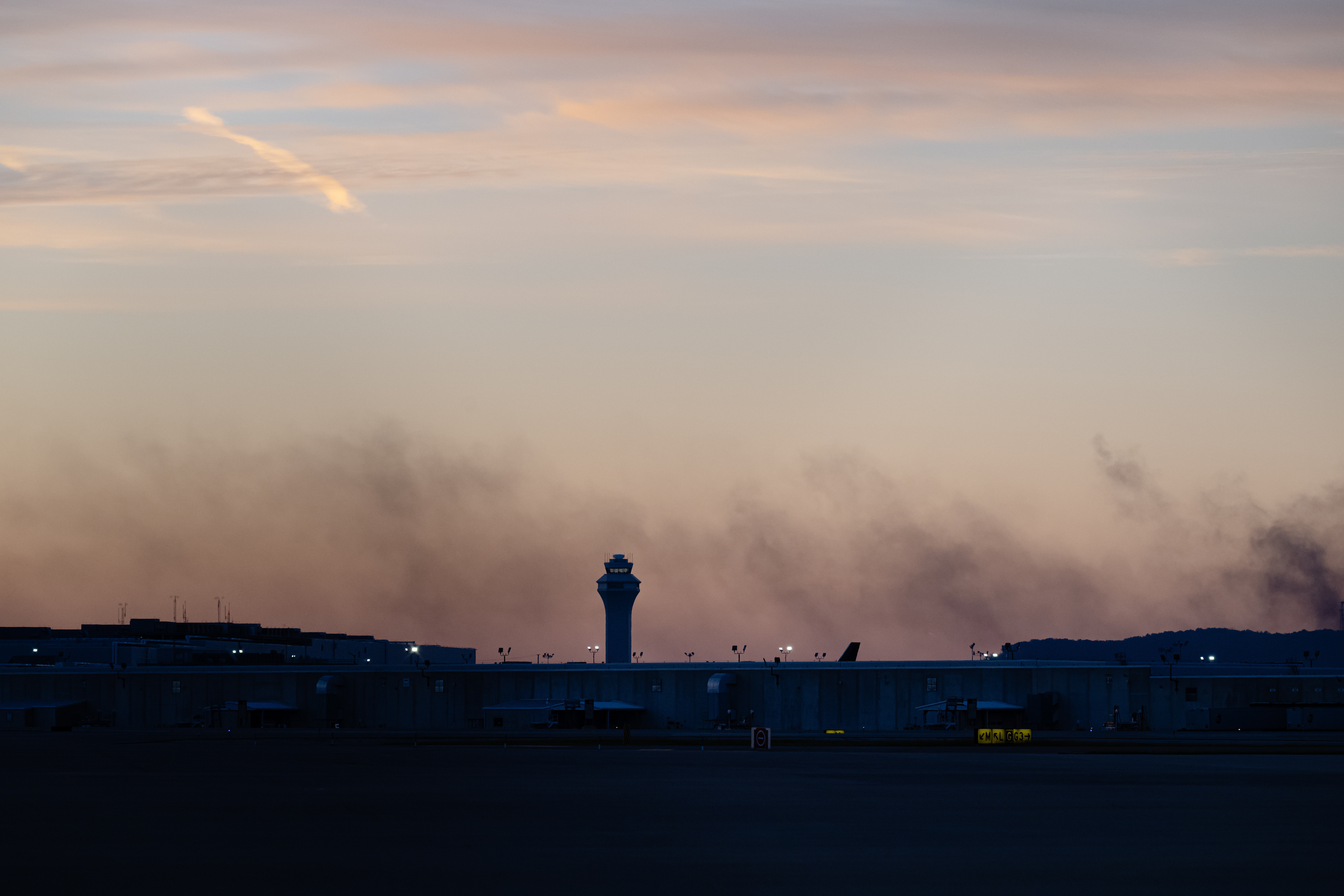 The ATC tower is seen while smoke rises from the crash site of UPS Flight 2976 near Louisville Muhammad Ali International Airport on Wednesday, Nov. 5, 2025, in Louisville, Ky.