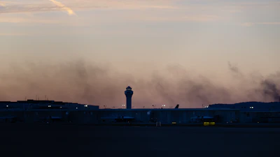 The ATC tower is seen while smoke rises from the crash site of UPS Flight 2976 near Louisville Muhammad Ali International Airport on Wednesday, Nov. 5, 2025, in Louisville, Ky.