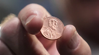 U.S. Treasurer Brandon Beach holds one of the last pennies pressed at the U.S. Mint, in Philadelphia, Nov. 12, 2025.