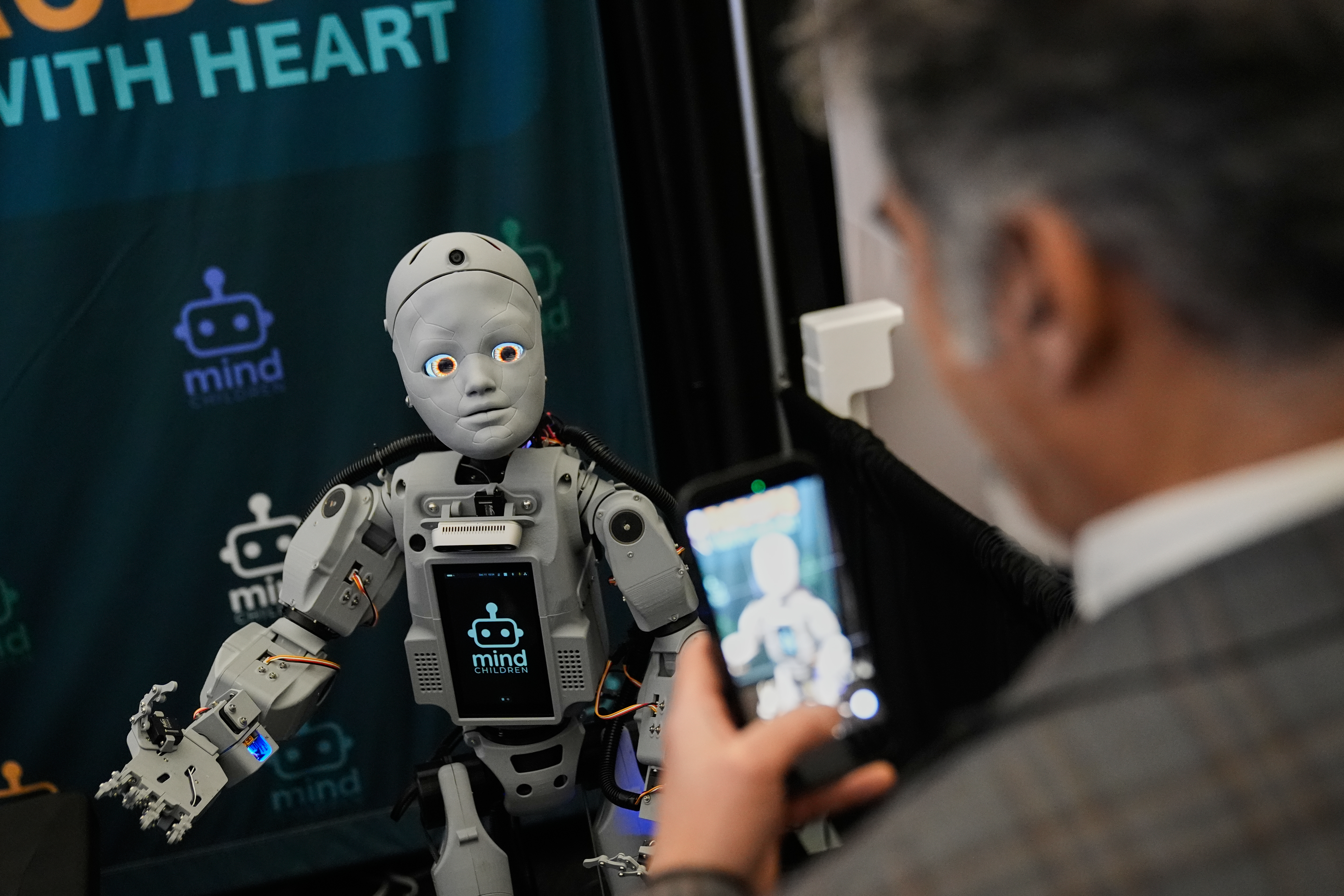 A man records a humanoid robot inside the exhibition room at the Humanoids Summit, Thursday, Dec. 11, 2025, in Mountain View, Calif.