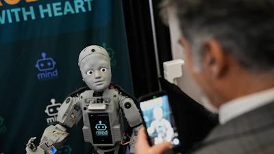 A man records a humanoid robot inside the exhibition room at the Humanoids Summit, Thursday, Dec. 11, 2025, in Mountain View, Calif.