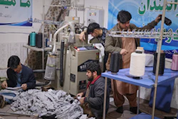 Local businessman Mohammad Amiri, 35, right, sorts out spools of thread for making socks as he works with his staff, all people with disabilities, in his sock production workshop in the western Afghan city of Herat, Afghanistan, Monday, Dec. 8, 2025.