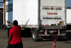 A student driver helps his classmate steer the wheel into the right direction as they practice driving in reverse in Calif., Nov. 17, 2021.