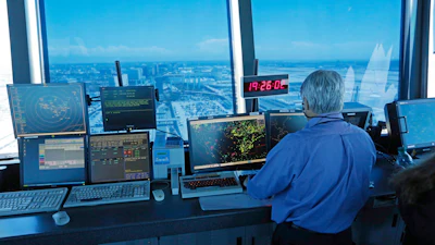 In this Sept. 4, 2013 photo, an air traffic controller works at computer screens and a digital clock showing Coordinated Universal Time (UTC), or Zulu time, is seen in this view looking eastward from the control tower at Los Angeles International Airport (LAX).