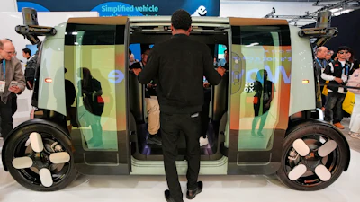 A man looks through the doors of a Zoox vehicle during the CES tech show Tuesday, Jan. 6, 2026, in Las Vegas.