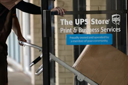 A UPS driver enters a United Parcel Service store with packages in Jackson, Miss., July 26, 2021.