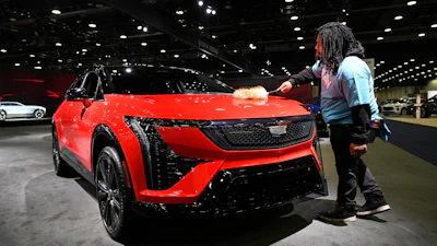 A worker dusts on a 2026 Cadillac Optiq Premium Sport vehicle at the Detroit Auto Show, Wednesday, Jan. 14, 2026, in Detroit.