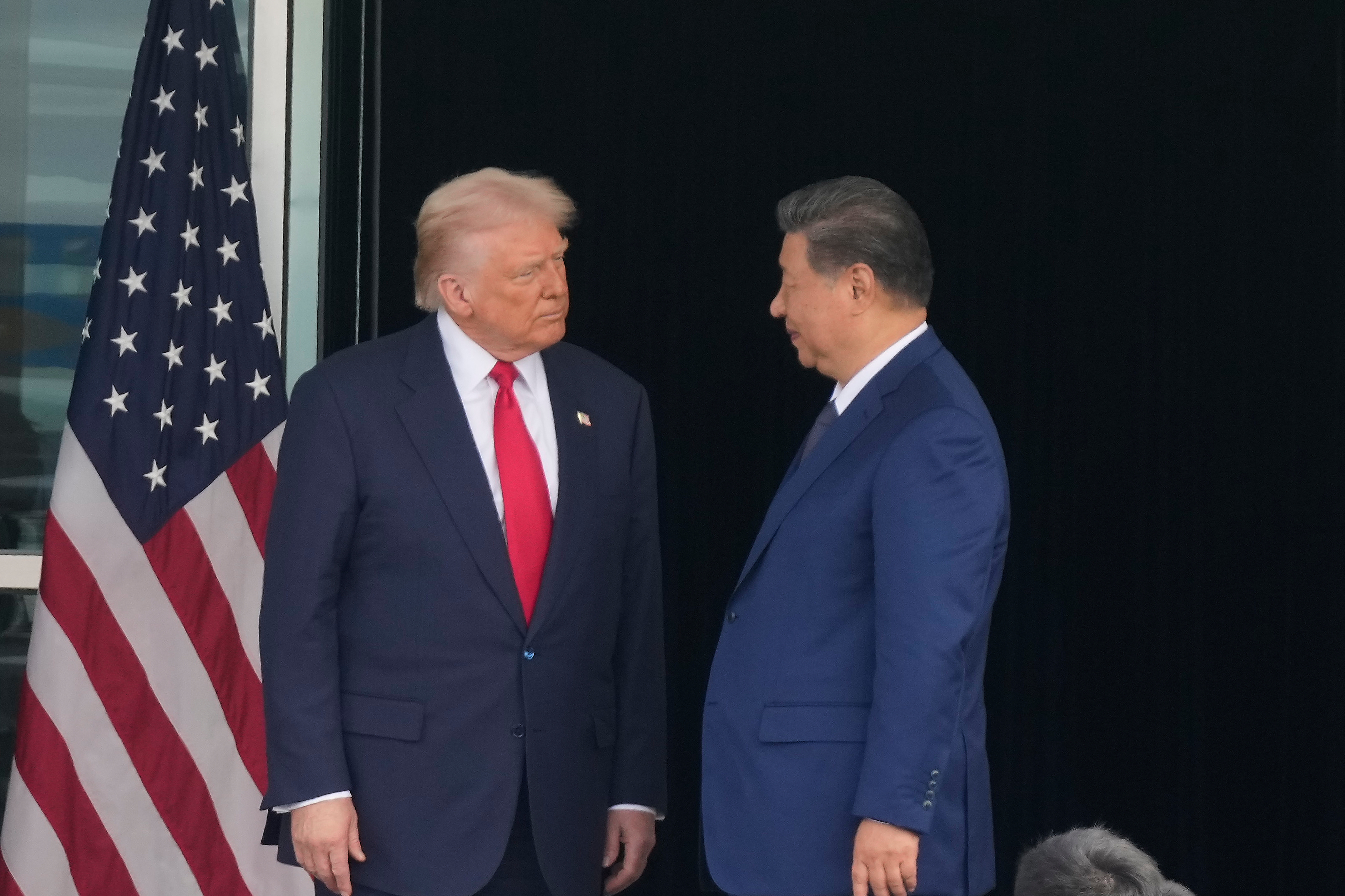 President Donald Trump, left, and Chinese President Xi Jinping, look at each other after their summit meeting at Gimhae International Airport Jinping in Busan, South Korea, Oct. 30, 2025.