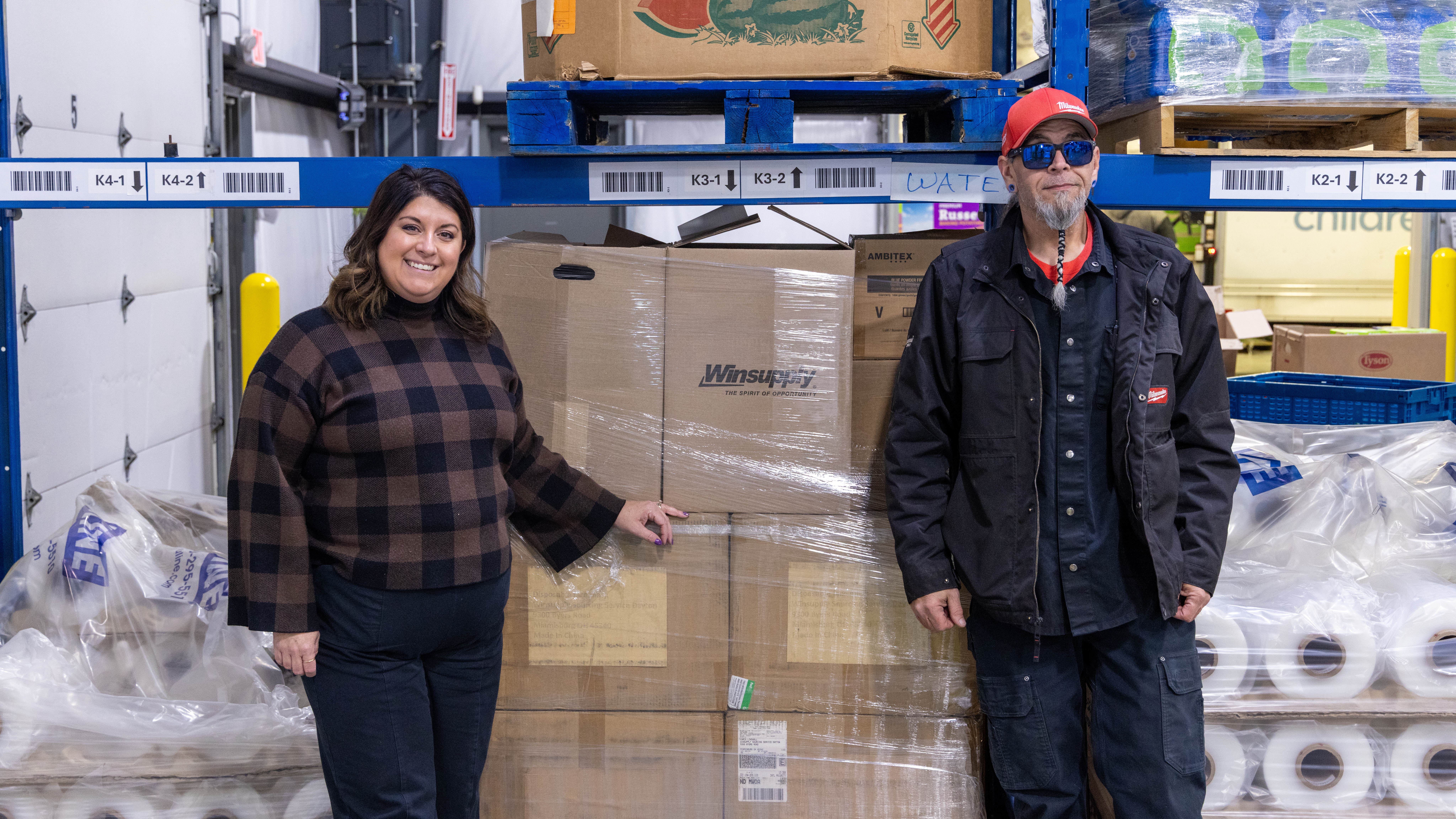 Lee Lauren Truesdale, chief development officer, Dayton Foodbank, with a Dayton Windustrial worker next to donations.